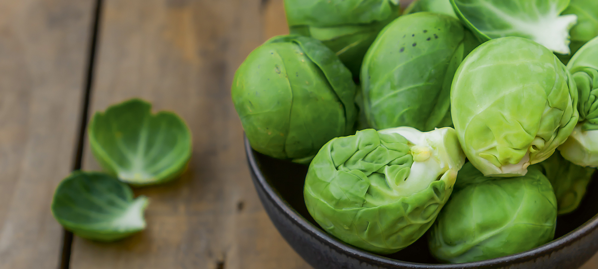 Klein, aber oho: Rosenkohl in einem Schälchen auf Holz